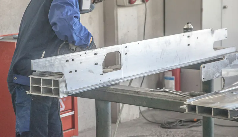Operario trabajando un perfil de aluminio