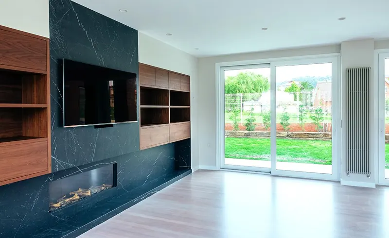 Salón reformado con mueble de televisión y chimenea